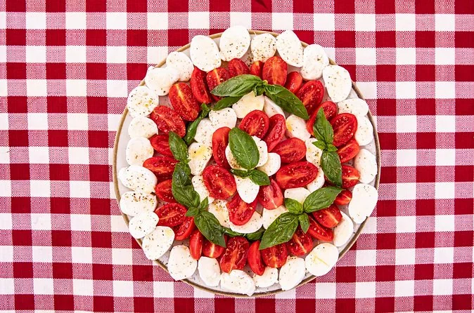Tomate, Mozzarella und Basilikum auf einer karierten Tischdecke