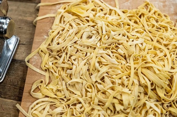 Rubans de pâtes fraîches aux œufs sur une planche en bois